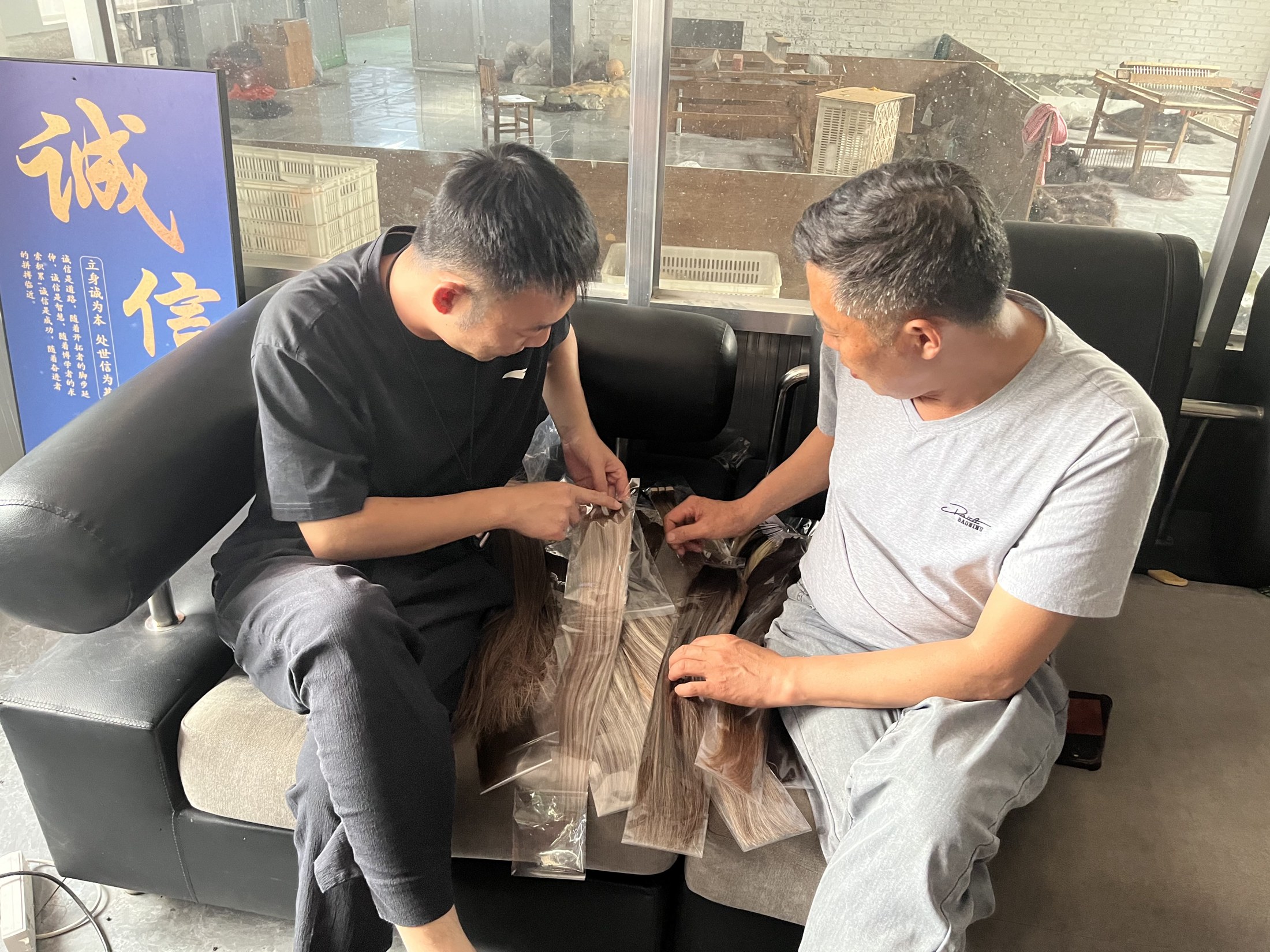 Two people looking closely at hair samples during a supplier discussion